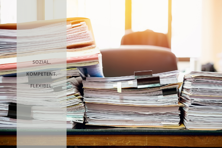 Auf einem Schreibtisch gestapelte Akten